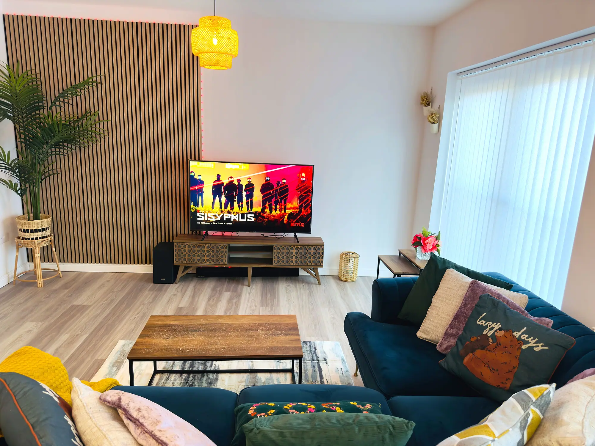 Open-plan living room with a velvet corner sofa and smart TV